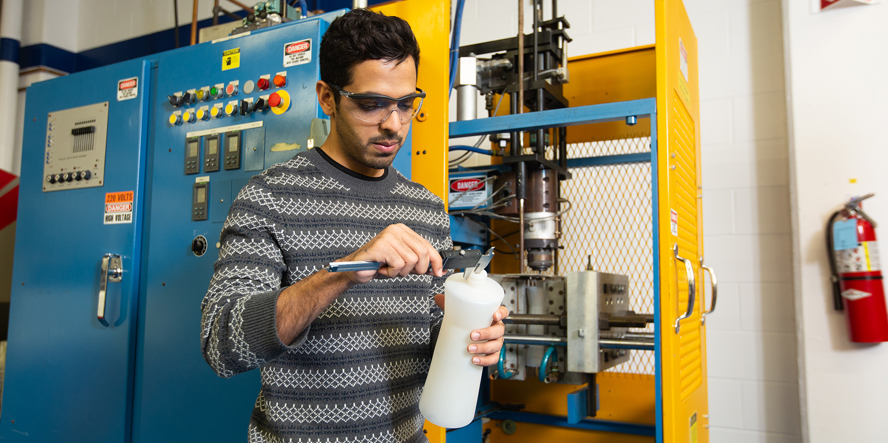 Student engages with advanced molding system in plastics engineering lab.