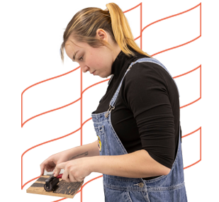 Student performs relief printing technique.