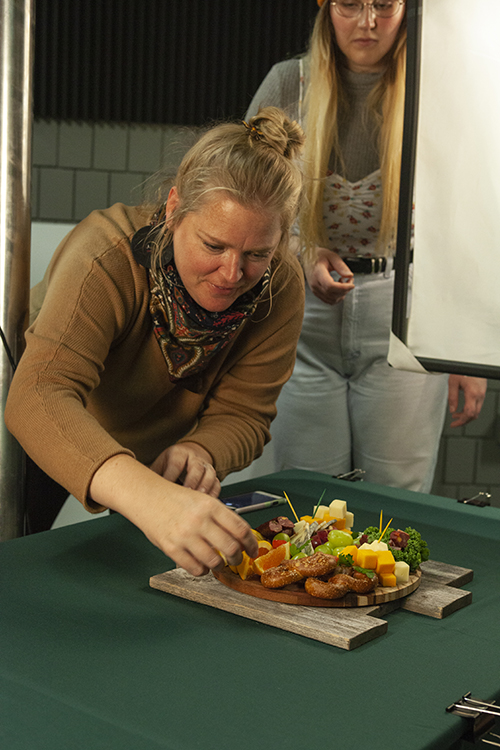 Students stylize cheese for a photo shoot