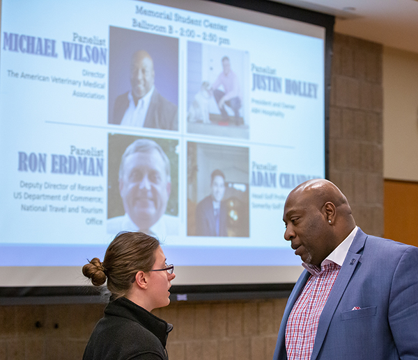 Michael Wilson talks with a student at the 50th anniversary event.