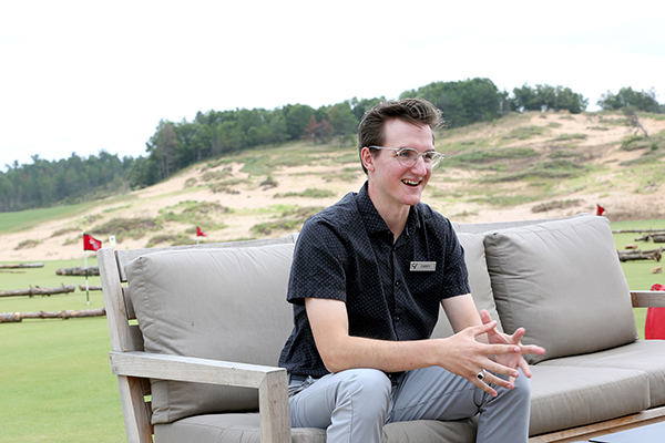 Casey Sabinash talks on a patio loverlooking the course.