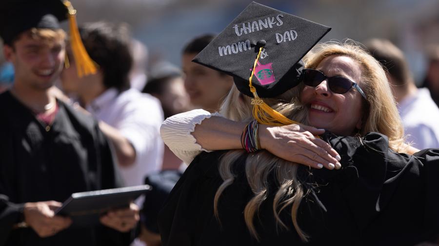 A graduate gets a hug after the spring 2022 commencement ceremony.