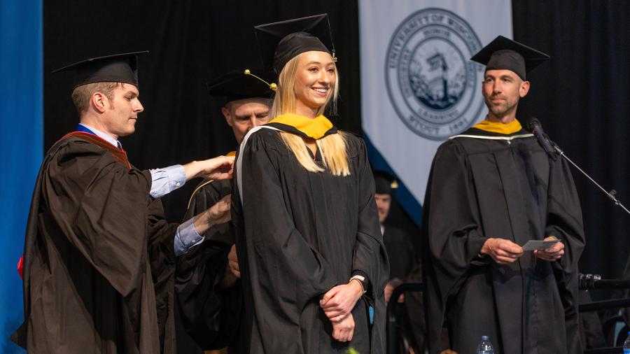 Casey Holmes, applied psychology, smiles during her hooding as part of receiving her master’s degree.