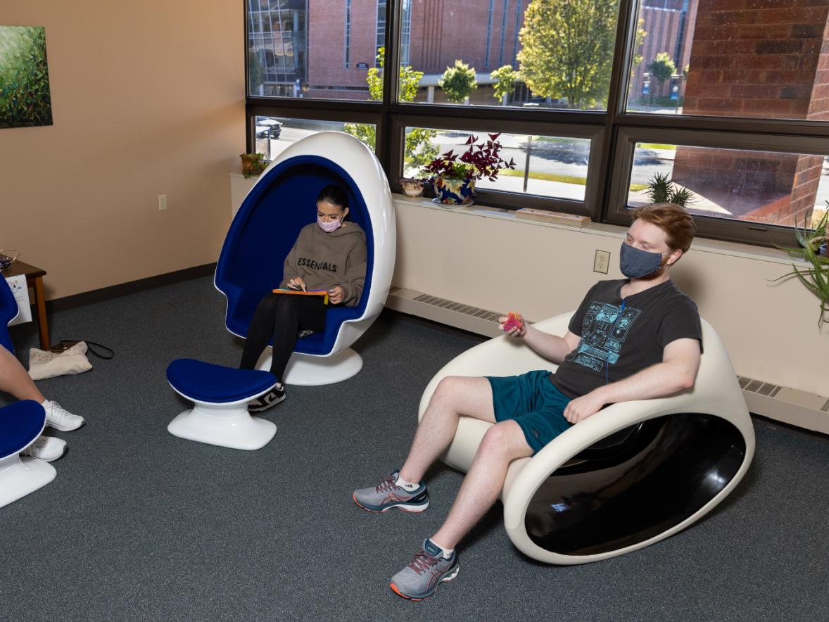 Students relax in noise-diffusing chairs and a rocking chair at the Sensory Space in the University Library. UW-Stout photo by Chris Cooper