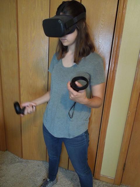 Mary Benetti, game design and development senior, demonstrating the Oculus Quest virtual reality headset.